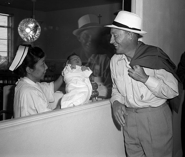 Bing Crosby looking at his newborn son, via Wikimedia Commons